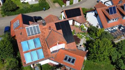 Luftaufnahme eines Wohnhauses mit Photovoltaikanlage und Solarthermie auf dem Ziegeldach
