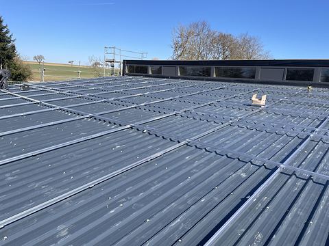 Montageschienen auf dem Trapezblechdach einer Halle in Schrozberg, vorbereitet für eine große Photovoltaikanlage