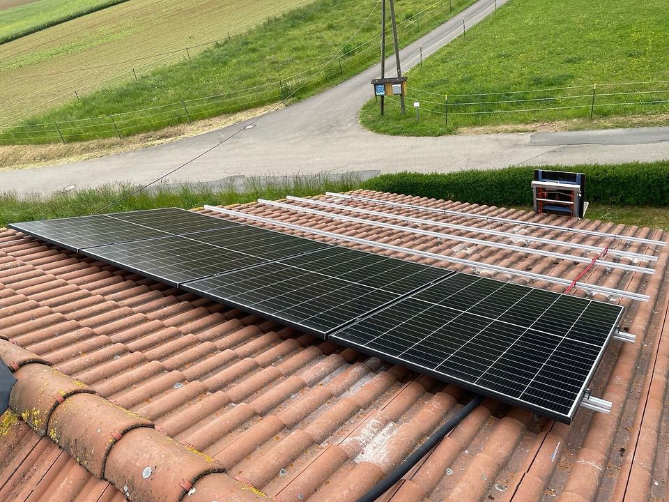 Solarmodule werden auf dem Ziegeldach eines Wohnhauses in Niederstetten Reihe für Reihe verlegt